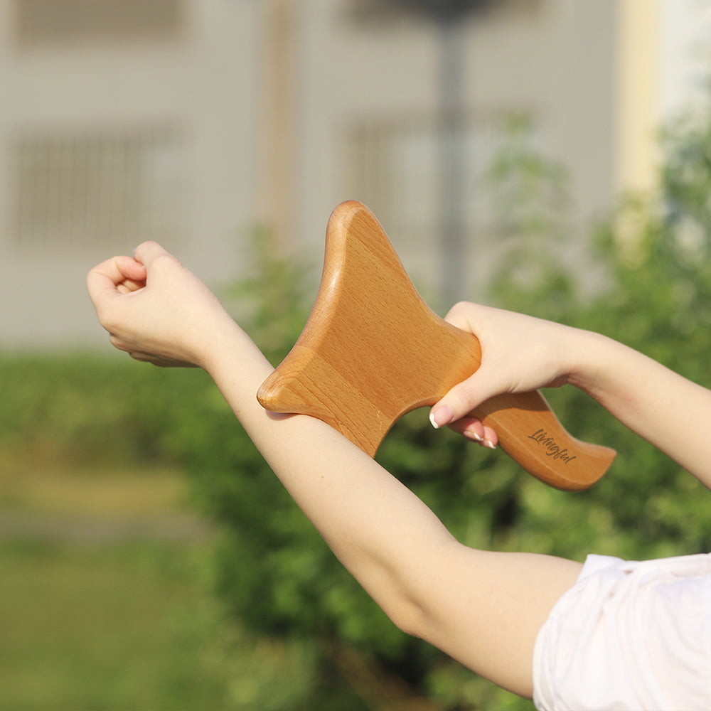 A person is outdoors using the Livingful Premium Wood Massage Tool 4 Sides on their forearm, experiencing the benefits of lymphatic drainage.