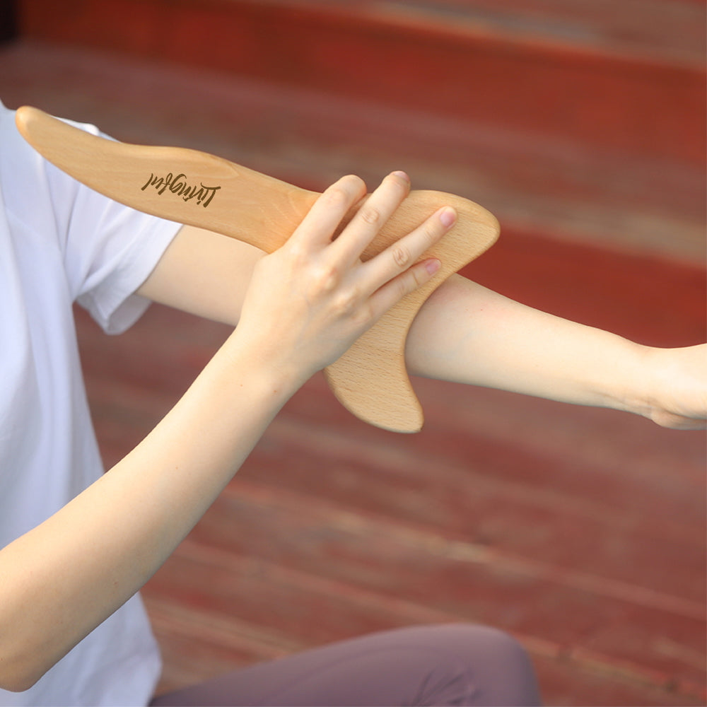 Using the Premium Wood Massage Tool 3 Sides by Livingful, a person skillfully applies Gua Sha techniques on their forearm for optimal relief.